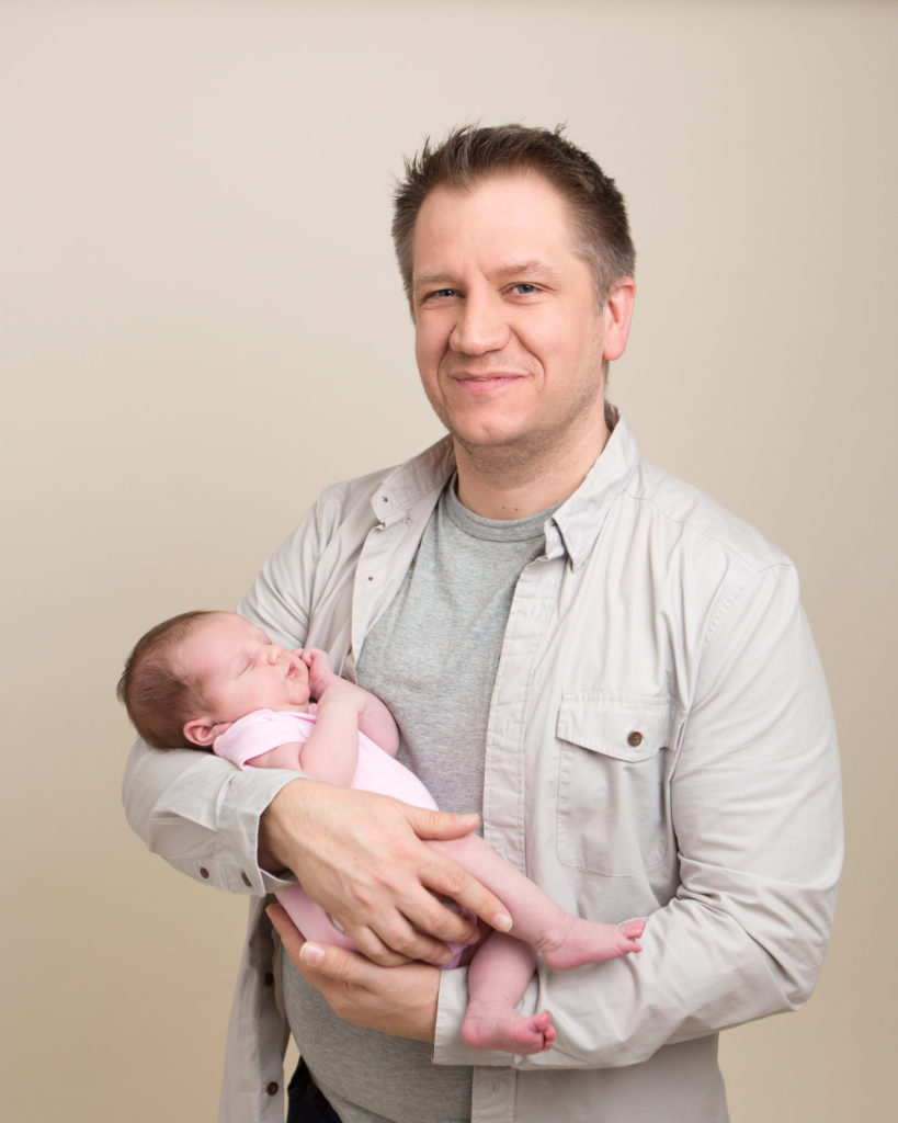 Proud Dad holding her daughter at there newborn photoshoot in Caerphilly